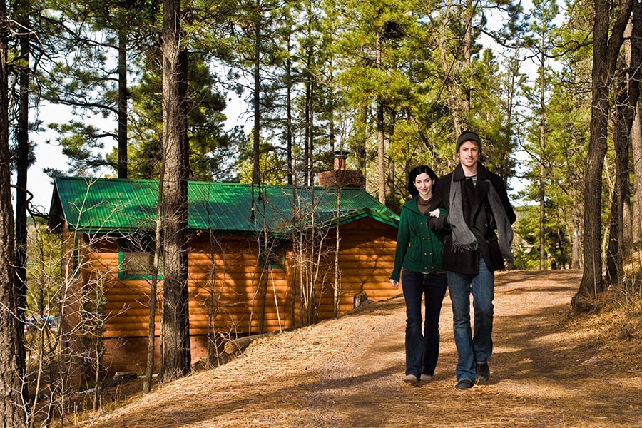 image of couple walking by a cabin in the woods