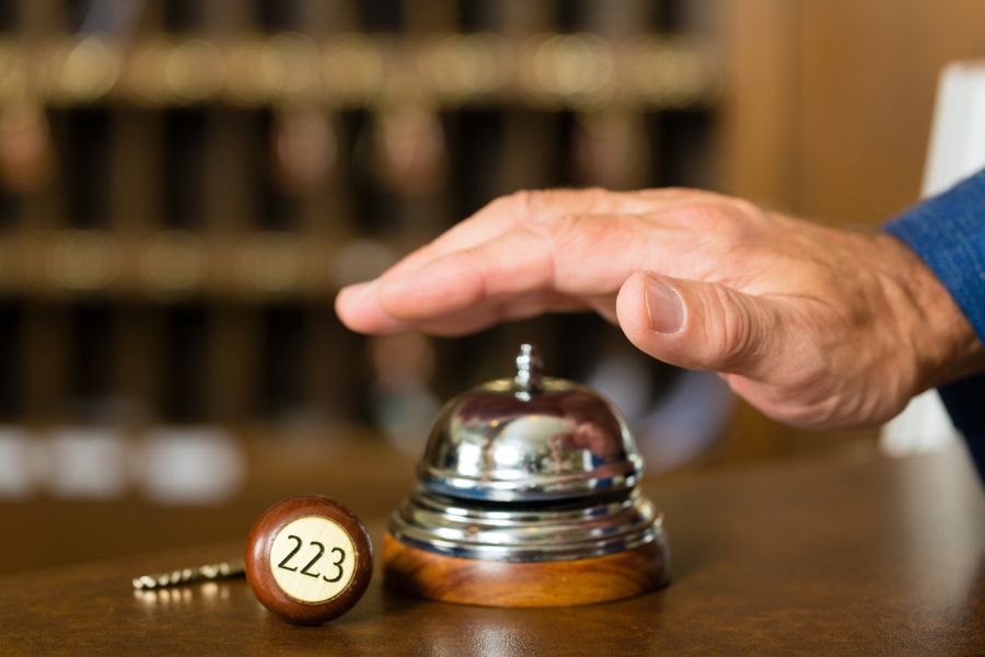 image of a hand ringing a check in bell at a hotel